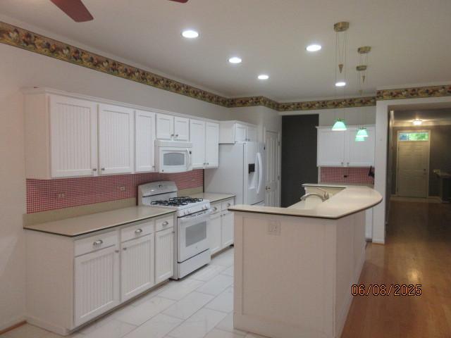 13005 Big Horn Dr, Huntley, IL 60142 - kitchen with white appliances, backsplash, white cabinetry, ceiling fan, and a center island