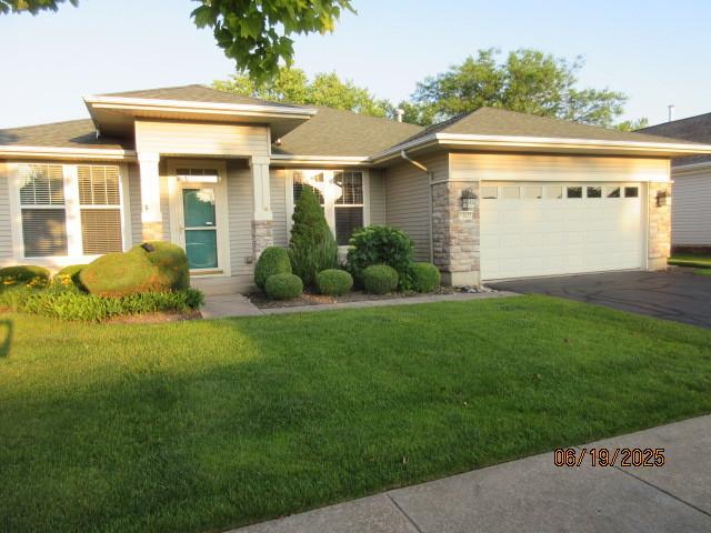 13005 Big Horn Dr, Huntley, IL 60142 - prairie-style home with driveway, an attached garage, a front lawn, and stone siding