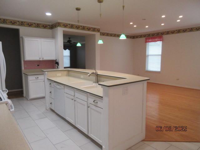 13005 Big Horn Dr, Huntley, IL 60142 - kitchen featuring dishwasher, white cabinets, light countertops, recessed lighting, and decorative light fixtures