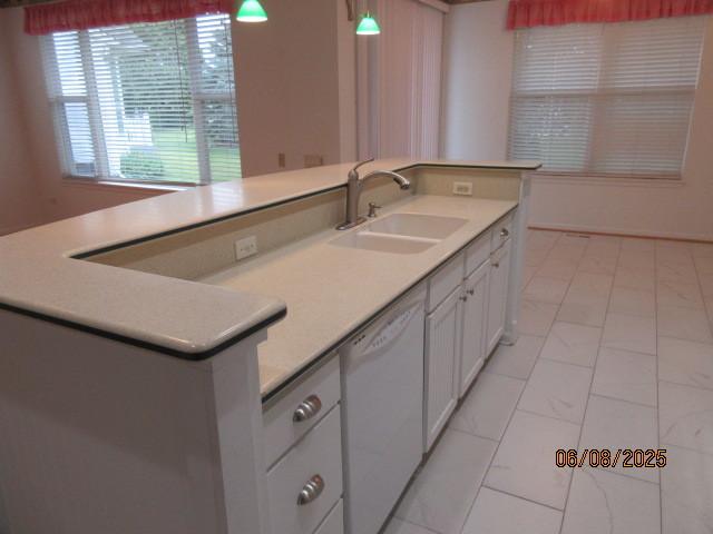 13005 Big Horn Dr, Huntley, IL 60142 - kitchen with white dishwasher, white cabinetry, light countertops, and pendant lighting