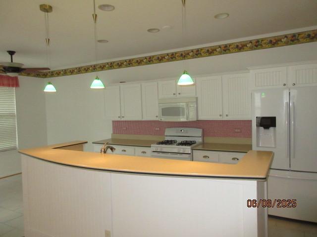 13005 Big Horn Dr, Huntley, IL 60142 - kitchen with white appliances, white cabinetry, a kitchen island, decorative backsplash, and light countertops