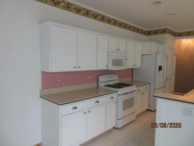 13005 Big Horn Dr, Huntley, IL 60142 - kitchen featuring white appliances, white cabinetry, and backsplash