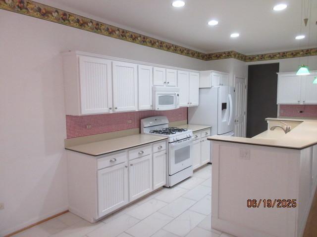 13005 Big Horn Dr, Huntley, IL 60142 - kitchen featuring white appliances, backsplash, white cabinetry, light countertops, and recessed lighting