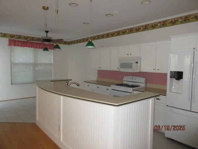13005 Big Horn Dr, Huntley, IL 60142 - kitchen featuring white appliances, white cabinets, decorative backsplash, an island with sink, and a ceiling fan