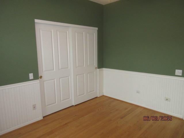 13005 Big Horn Dr, Huntley, IL 60142 - unfurnished bedroom featuring a wainscoted wall, wood finished floors, and a closet