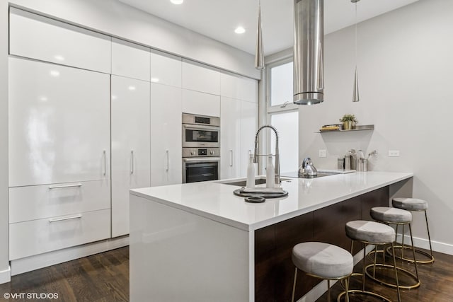 1718 W Le Moyne St Unit 1, Chicago, IL 60622 - kitchen featuring double oven, modern cabinets, white cabinets, a kitchen breakfast bar, and dark wood-style floors