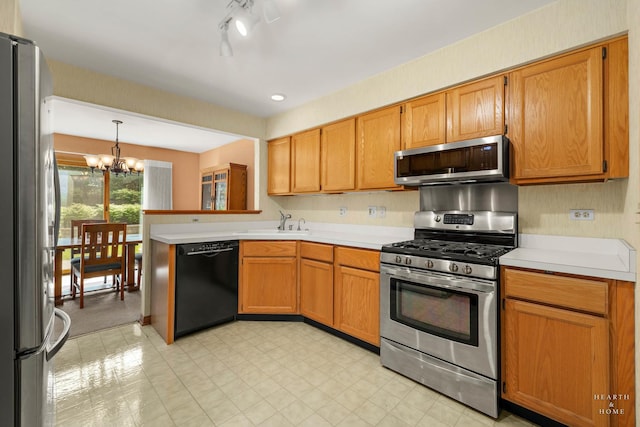 314 Spring Creek Cir, Schaumburg, IL 60173 - kitchen with appliances with stainless steel finishes, a chandelier, light countertops, light floors, and a peninsula