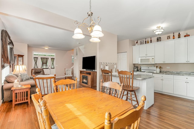 4115 Dalewood Dr, Plainfield, IL 60586 - dining room with light wood-style flooring, a chandelier, and a glass covered fireplace