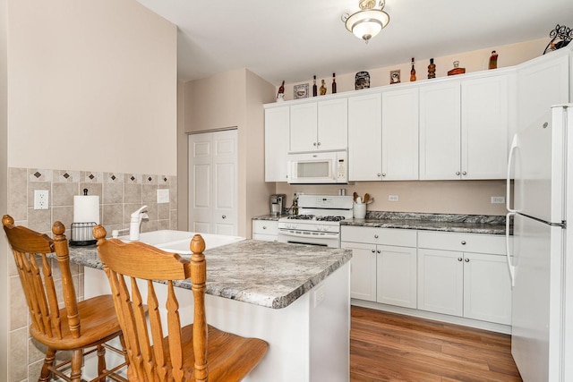 4115 Dalewood Dr, Plainfield, IL 60586 - kitchen featuring white appliances, a kitchen breakfast bar, white cabinetry, tile walls, and light wood finished floors