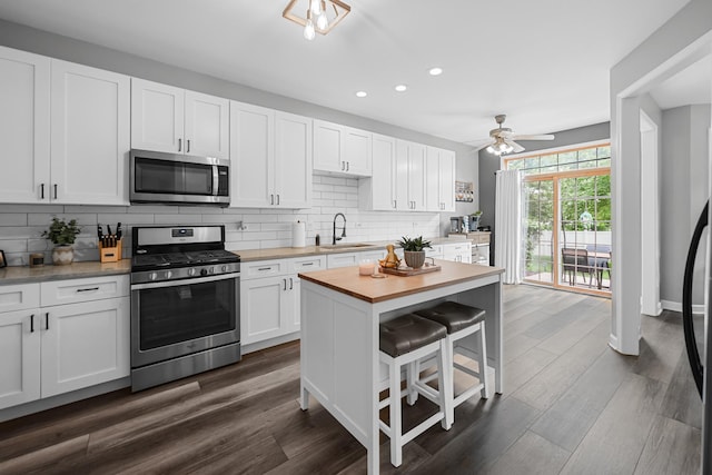 8033 Nielsen Dr, Tinley Park, IL 60477 - kitchen with appliances with stainless steel finishes, recessed lighting, backsplash, white cabinets, and a kitchen bar