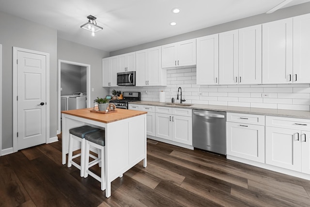 8033 Nielsen Dr, Tinley Park, IL 60477 - kitchen with stainless steel appliances, separate washer and dryer, wood counters, recessed lighting, and a kitchen bar