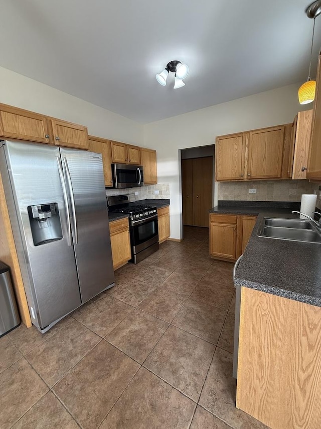 710 Silver Leaf Ct, Joliet, IL 60431 - kitchen with stainless steel appliances, backsplash, dark countertops, dark tile patterned floors, and pendant lighting