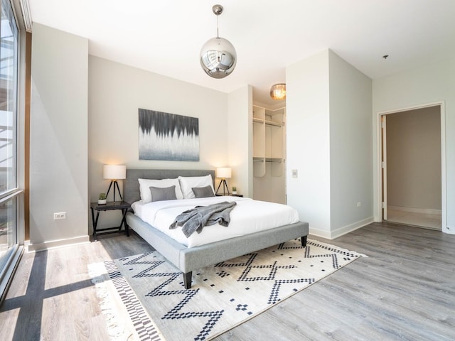 653 N Kingsbury St Unit 1707, Chicago, IL 60654 - bedroom with wood finished floors and a walk in closet