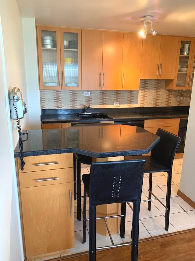 4250 N Marine Dr Unit 1404, Chicago, IL 60613 - kitchen with decorative backsplash, glass insert cabinets, light brown cabinets, dark stone countertops, and light tile patterned floors