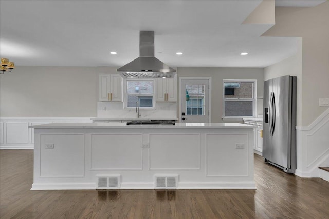 3935 W Jarvis Ave, Lincolnwood, IL 60712 - kitchen featuring stainless steel refrigerator with ice dispenser, island exhaust hood, light countertops, gas stovetop, and white cabinetry