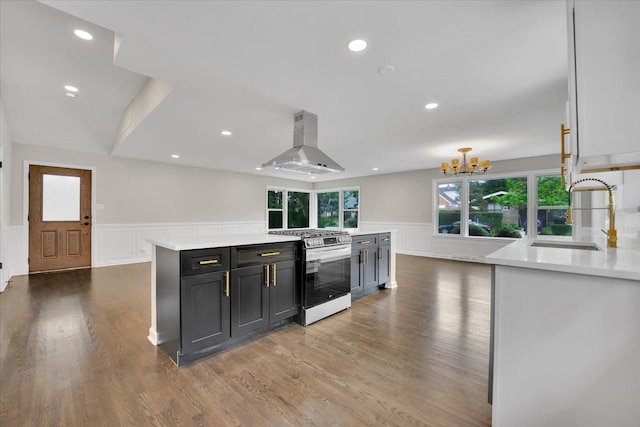 3935 W Jarvis Ave, Lincolnwood, IL 60712 - kitchen featuring stainless steel gas range, island range hood, a decorative wall, a chandelier, and light countertops