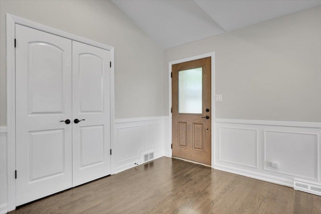 3935 W Jarvis Ave, Lincolnwood, IL 60712 - foyer entrance featuring lofted ceiling, a wainscoted wall, wood finished floors, and a decorative wall