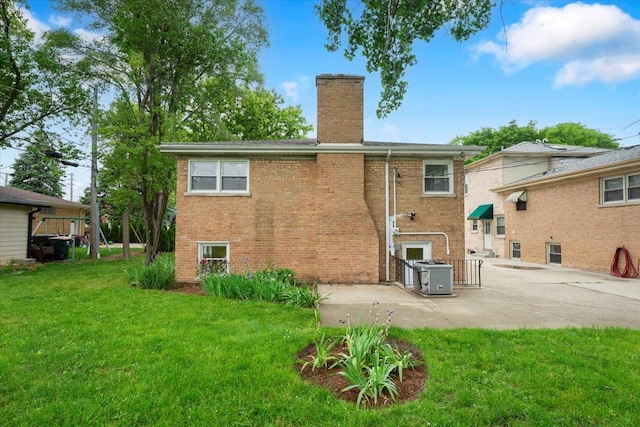 3935 W Jarvis Ave, Lincolnwood, IL 60712 - back of house featuring a chimney, brick siding, a patio area, and a yard