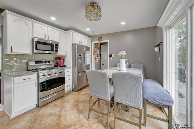 8246 N Applewood Ct, Hanover Park, IL 60133 - kitchen featuring stainless steel appliances, white cabinetry, tasteful backsplash, recessed lighting, and light stone countertops