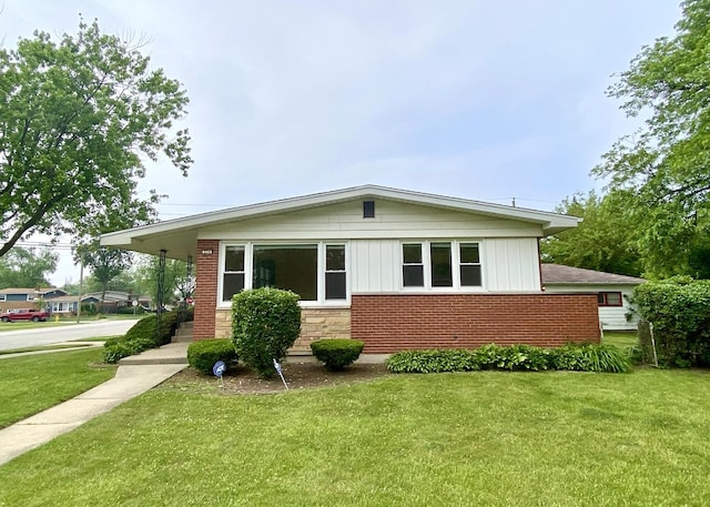 234 Tahoe Dr, Chicago Heights, IL 60411 - view of front of property with a front yard, brick siding, and board and batten siding
