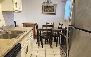 1915 Whitechapel Dr Unit 1A, Mount Prospect, IL 60056 - kitchen with appliances with stainless steel finishes, light tile patterned floors, white cabinetry, and light countertops