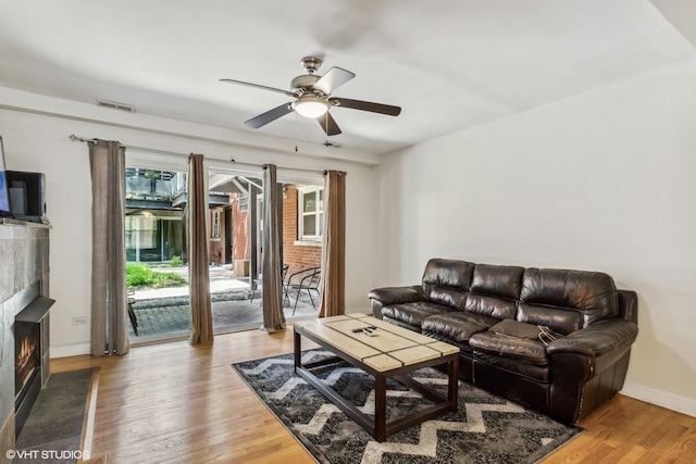 6427 N Damen Ave Unit 1E, Chicago, IL 60645 - living area featuring a ceiling fan, healthy amount of natural light, light wood-style flooring, and a lit fireplace