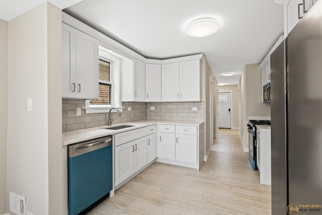 8207 S Laflin St, Chicago, IL 60620 - kitchen with appliances with stainless steel finishes, light countertops, white cabinetry, and decorative backsplash