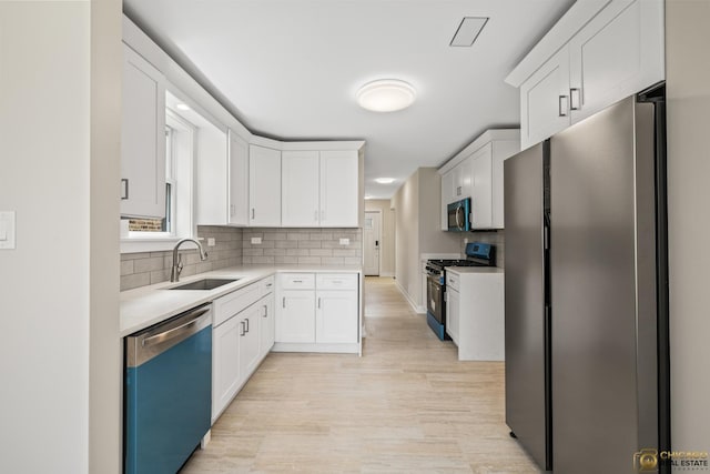 8207 S Laflin St, Chicago, IL 60620 - kitchen with appliances with stainless steel finishes, white cabinets, light countertops, backsplash, and light wood-style floors