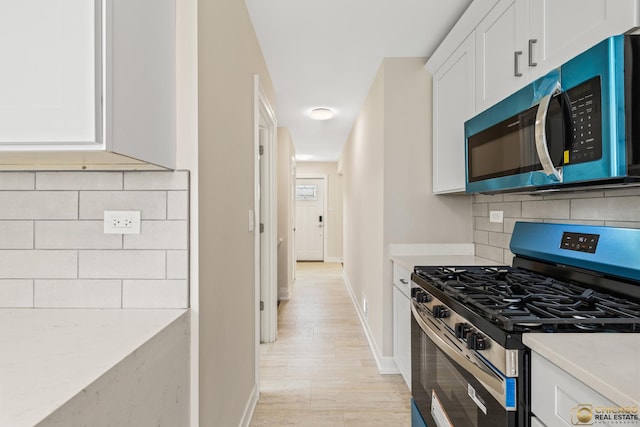 8207 S Laflin St, Chicago, IL 60620 - kitchen featuring stainless steel appliances, white cabinets, decorative backsplash, and light countertops
