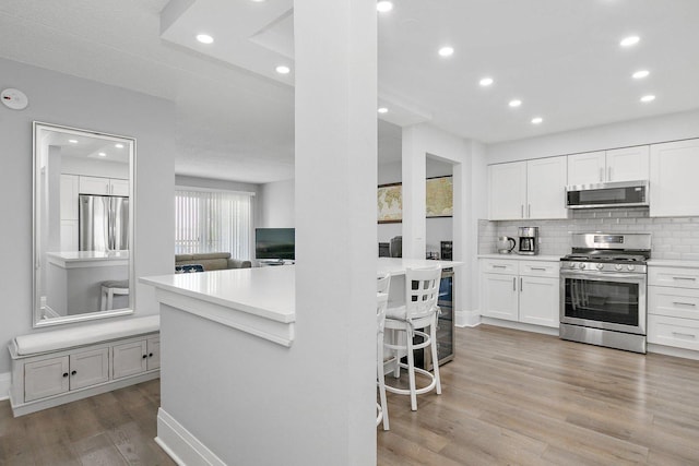 4210 N Natchez Ave Unit 208, Chicago, IL 60634 - kitchen featuring appliances with stainless steel finishes, light wood-style flooring, backsplash, light countertops, and recessed lighting