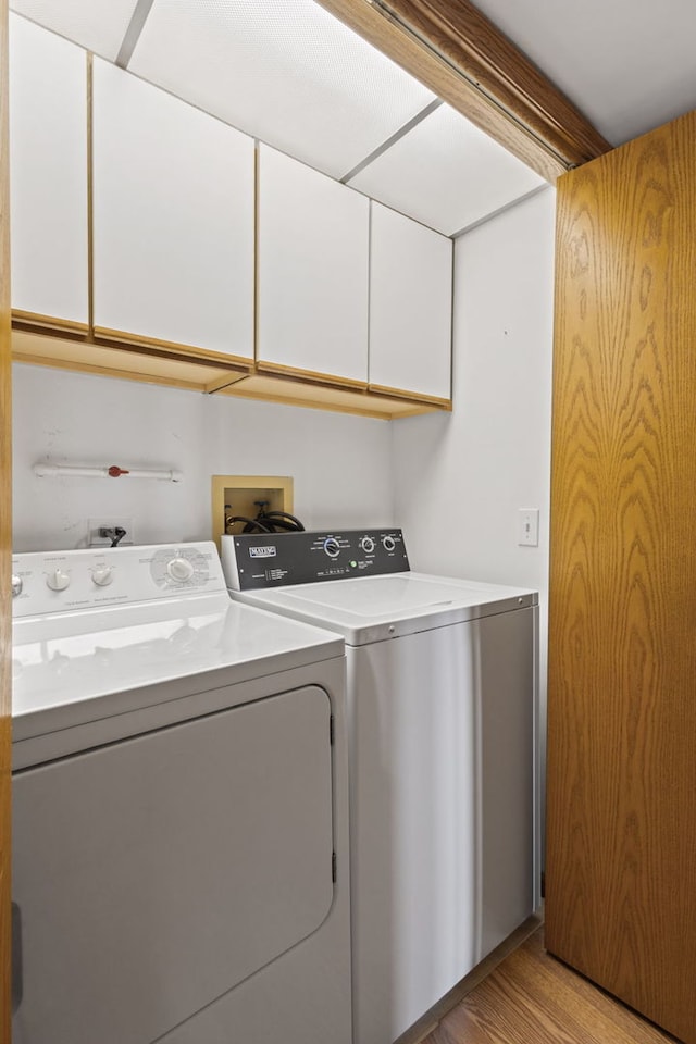 8540 W Foster Ave Unit 505, Norridge, IL 60706 - laundry room featuring washer and clothes dryer, cabinet space, and light wood-style flooring