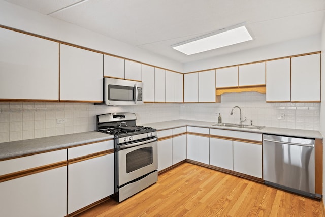 8540 W Foster Ave Unit 505, Norridge, IL 60706 - kitchen with stainless steel appliances, white cabinetry, light wood-style flooring, and tasteful backsplash
