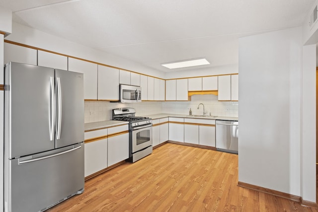 8540 W Foster Ave Unit 505, Norridge, IL 60706 - kitchen with stainless steel appliances, light countertops, backsplash, light wood finished floors, and white cabinets