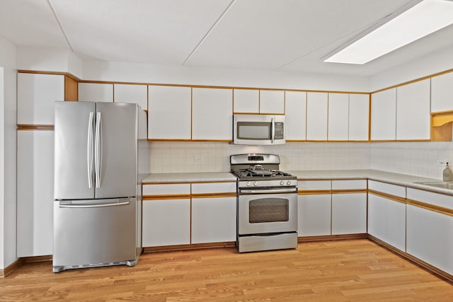 8540 W Foster Ave Unit 505, Norridge, IL 60706 - kitchen featuring stainless steel appliances, white cabinets, light countertops, and light wood-style flooring