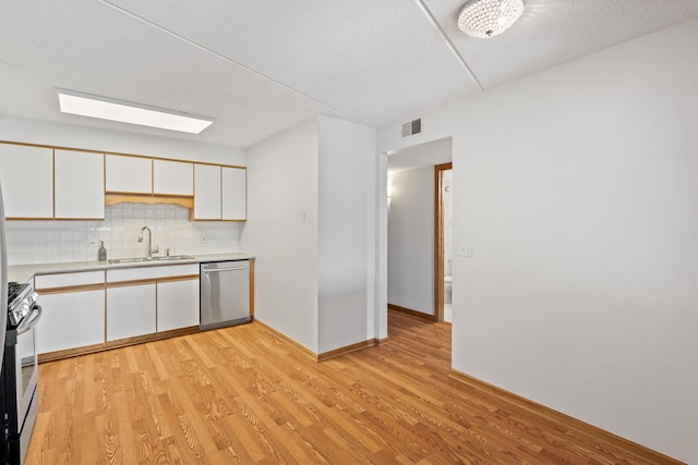 8540 W Foster Ave Unit 505, Norridge, IL 60706 - kitchen with stainless steel appliances, light countertops, light wood-style flooring, backsplash, and white cabinetry
