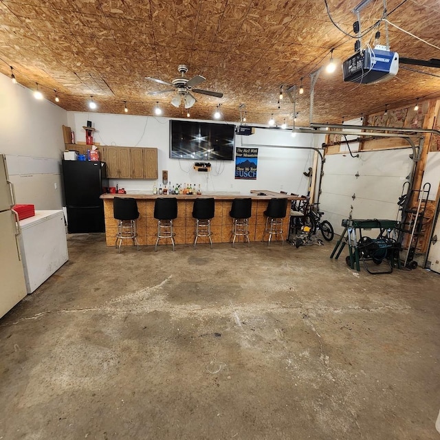 3883 E 2050th Rd, Serena, IL 60549 - garage featuring freestanding refrigerator, a garage door opener, and a ceiling fan