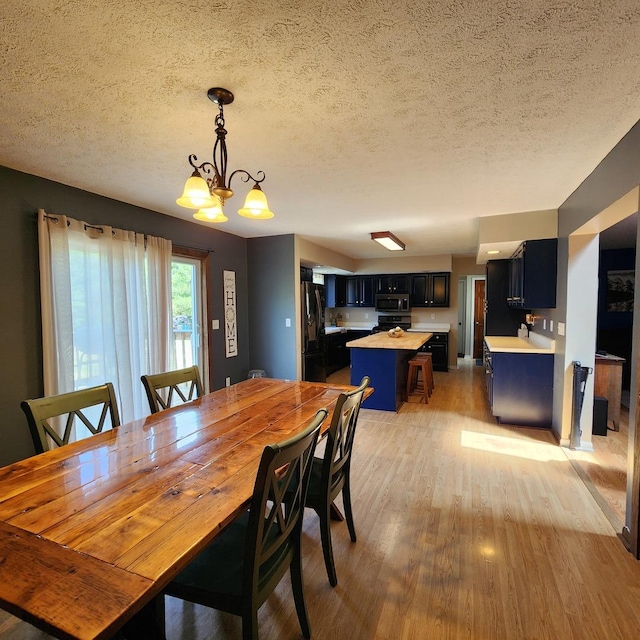3883 E 2050th Rd, Serena, IL 60549 - dining area featuring light wood-style flooring, a chandelier, and a textured ceiling