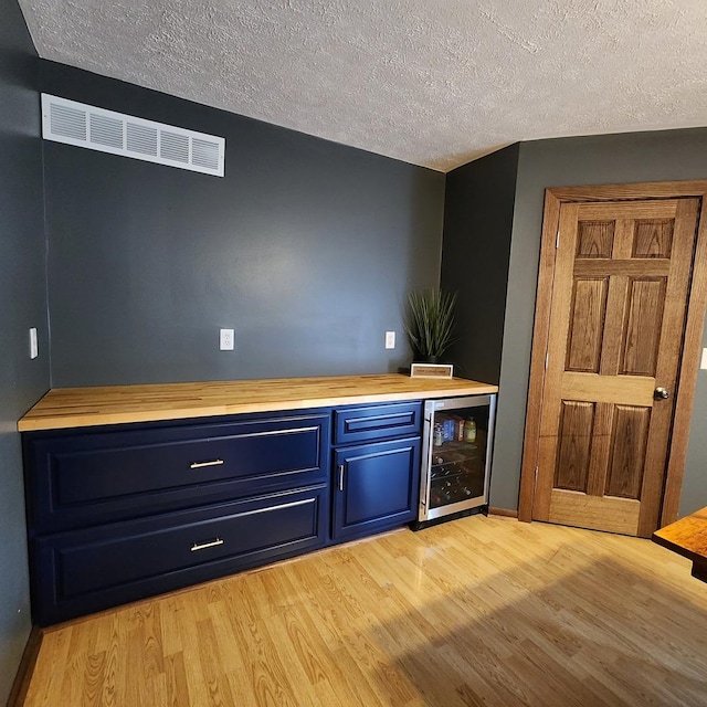 3883 E 2050th Rd, Serena, IL 60549 - indoor dry bar with wine cooler, light wood-style floors, and a textured ceiling