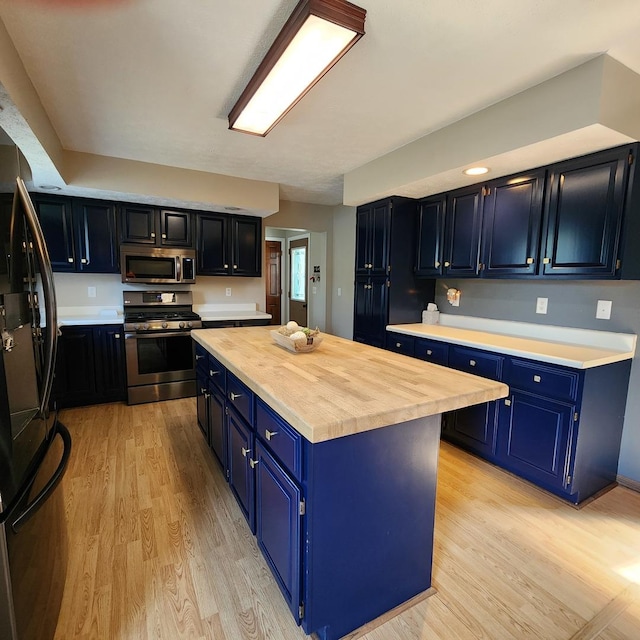 3883 E 2050th Rd, Serena, IL 60549 - kitchen with stainless steel appliances, blue cabinetry, a kitchen island, and light wood finished floors