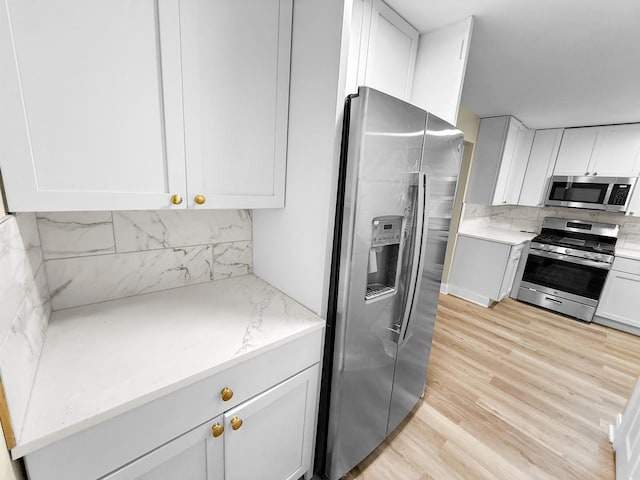 16802 Anthony Ave, Hazel Crest, IL 60429 - kitchen featuring appliances with stainless steel finishes, light wood-style flooring, white cabinetry, and backsplash