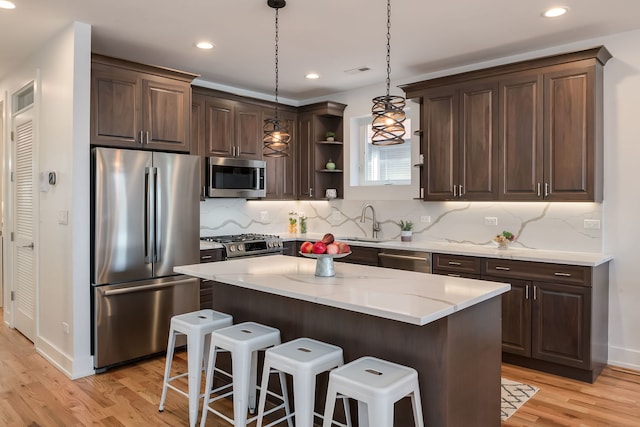 1415 W Walton St Unit 3, Chicago, IL 60642 - kitchen with appliances with stainless steel finishes, open shelves, light wood-type flooring, a breakfast bar area, and dark brown cabinets