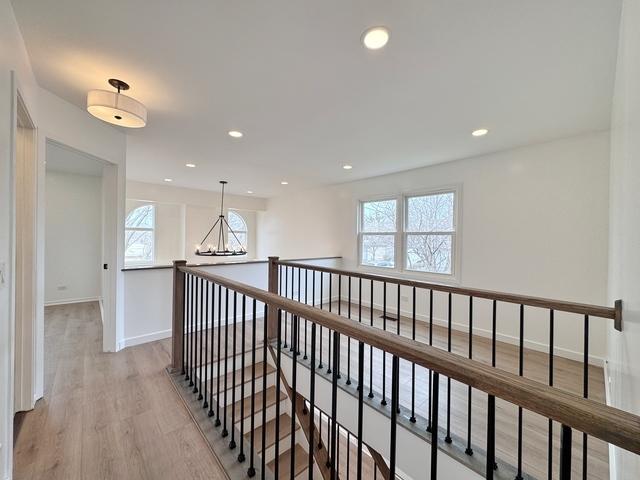 2326 Hamilton Pl, Schaumburg, IL 60194 - hallway with plenty of natural light, light wood finished floors, a chandelier, recessed lighting, and an upstairs landing