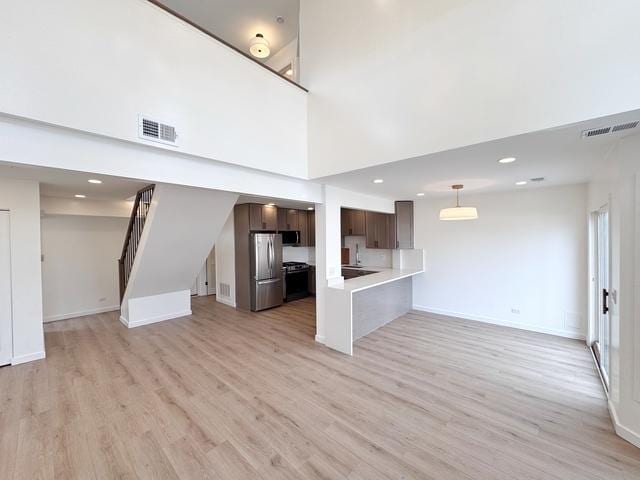 2326 Hamilton Pl, Schaumburg, IL 60194 - unfurnished living room with light wood-type flooring, stairway, a high ceiling, and recessed lighting