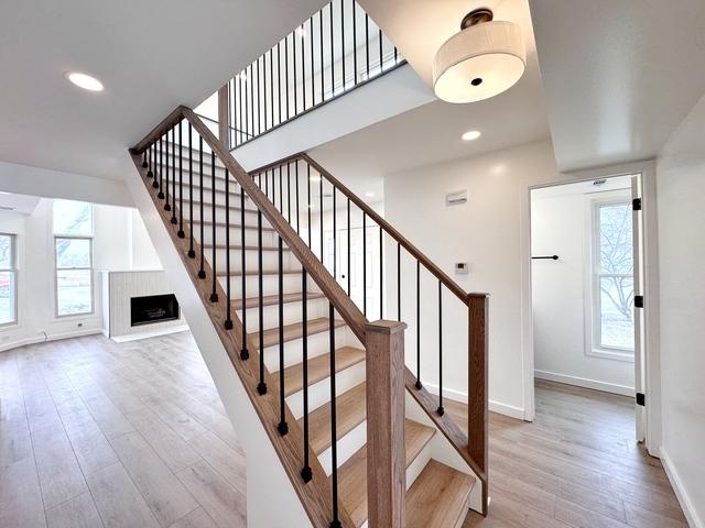 2326 Hamilton Pl, Schaumburg, IL 60194 - staircase featuring wood finished floors, a fireplace, and recessed lighting