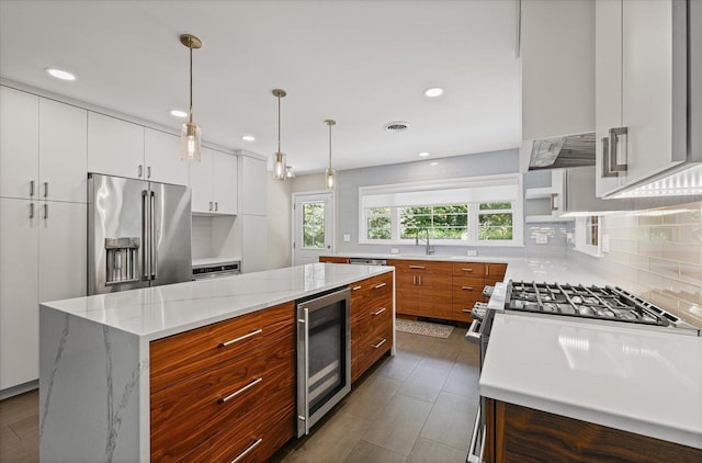32 Greencroft Dr, Champaign, IL 61821 - kitchen with beverage cooler, high end refrigerator, white gas range oven, decorative backsplash, and white cabinetry