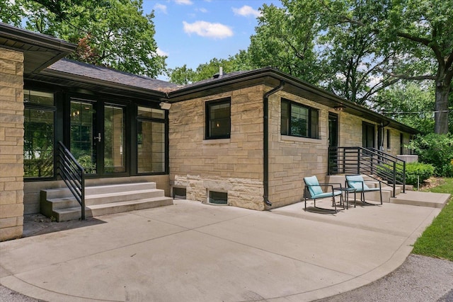 32 Greencroft Dr, Champaign, IL 61821 - rear view of house with stone siding, entry steps, french doors, and a patio