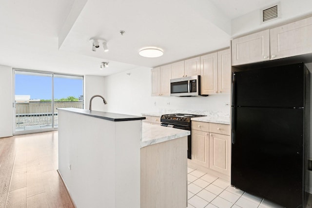 1640 Maple Ave Unit 503, Evanston, IL 60201 - kitchen featuring black appliances, a kitchen island with sink, expansive windows, and light countertops