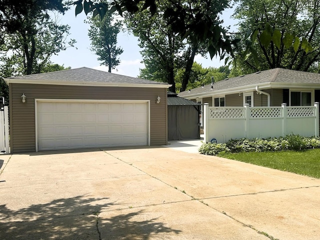 1517 Juniper Ln, Machesney Park, IL 61115 - view of front of property with an outbuilding, a detached garage, and a shingled roof