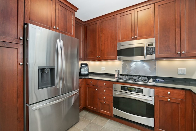 600 N Lake Shore Dr Unit 814, Chicago, IL 60611 - kitchen featuring appliances with stainless steel finishes, dark countertops, tasteful backsplash, and light tile patterned flooring