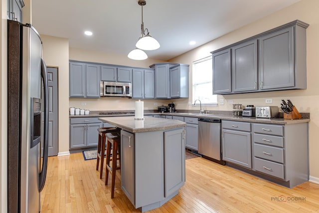 337A Veronica Cir, Bartlett, IL 60103 - kitchen with appliances with stainless steel finishes, gray cabinetry, light wood-style flooring, a kitchen bar, and recessed lighting